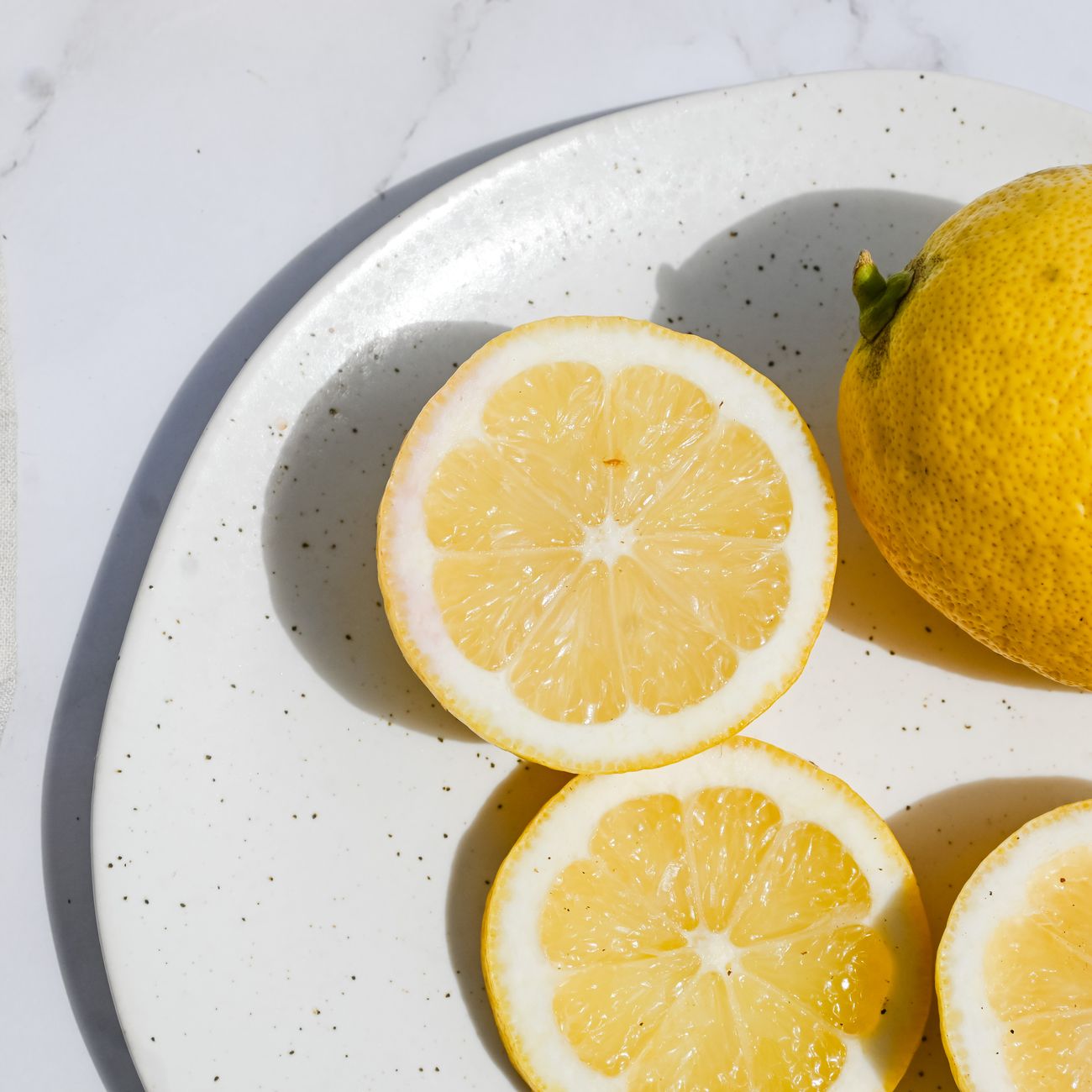 Bright yellow yuzu citrus fruits floating in a traditional Japanese wooden bathtub filled with steaming hot water.