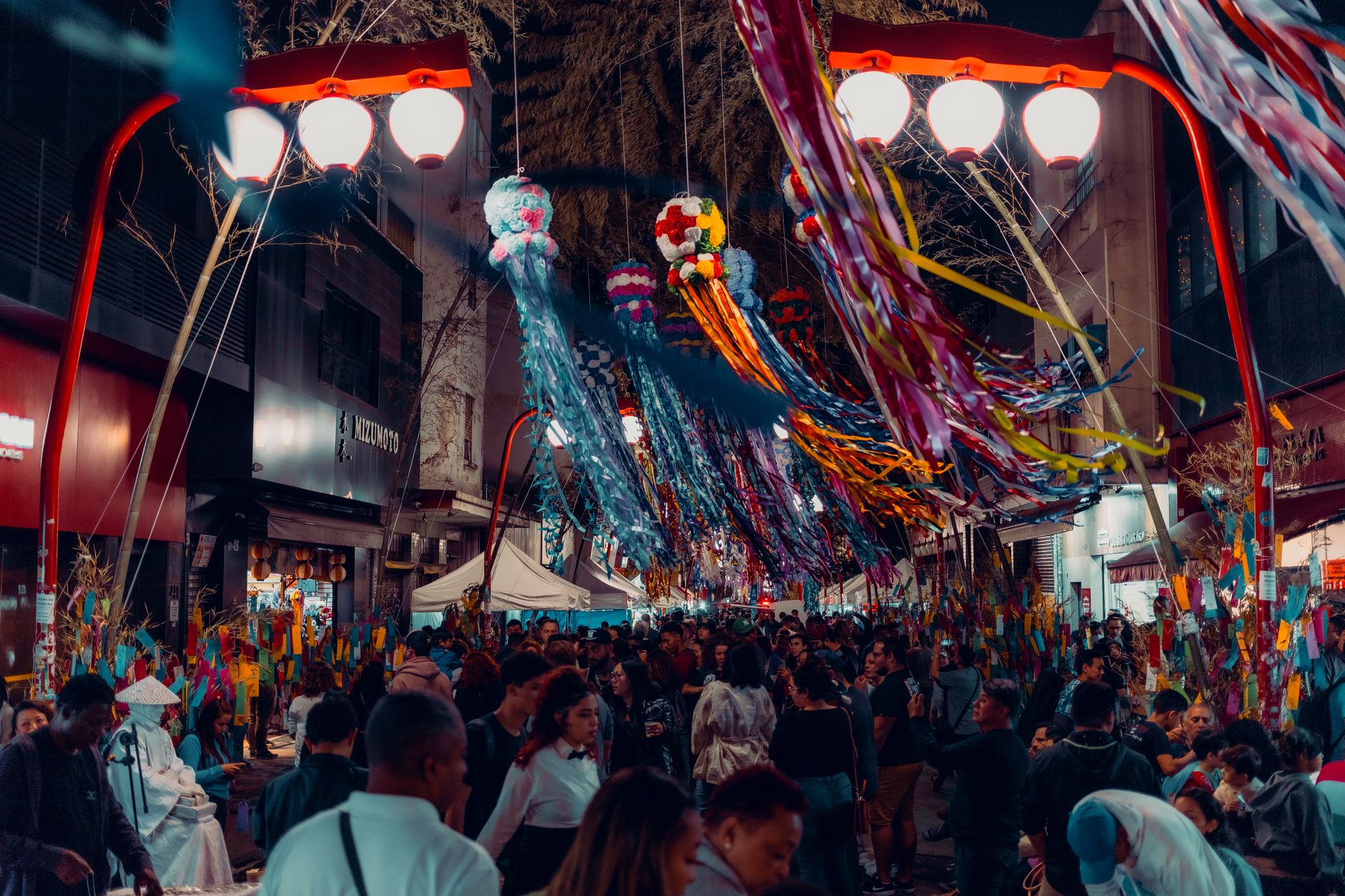 Colorful paper strips and origami decorations hanging from bamboo branches during Japan's summer Tanabata Star Festival celebration.
