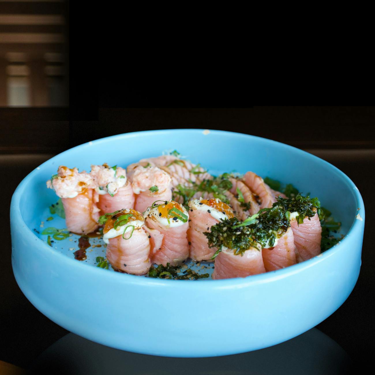 Traditional Japanese meal arranged on a wooden tray with rice, miso soup, grilled fish, pickles, and vegetables in separate small bowls.