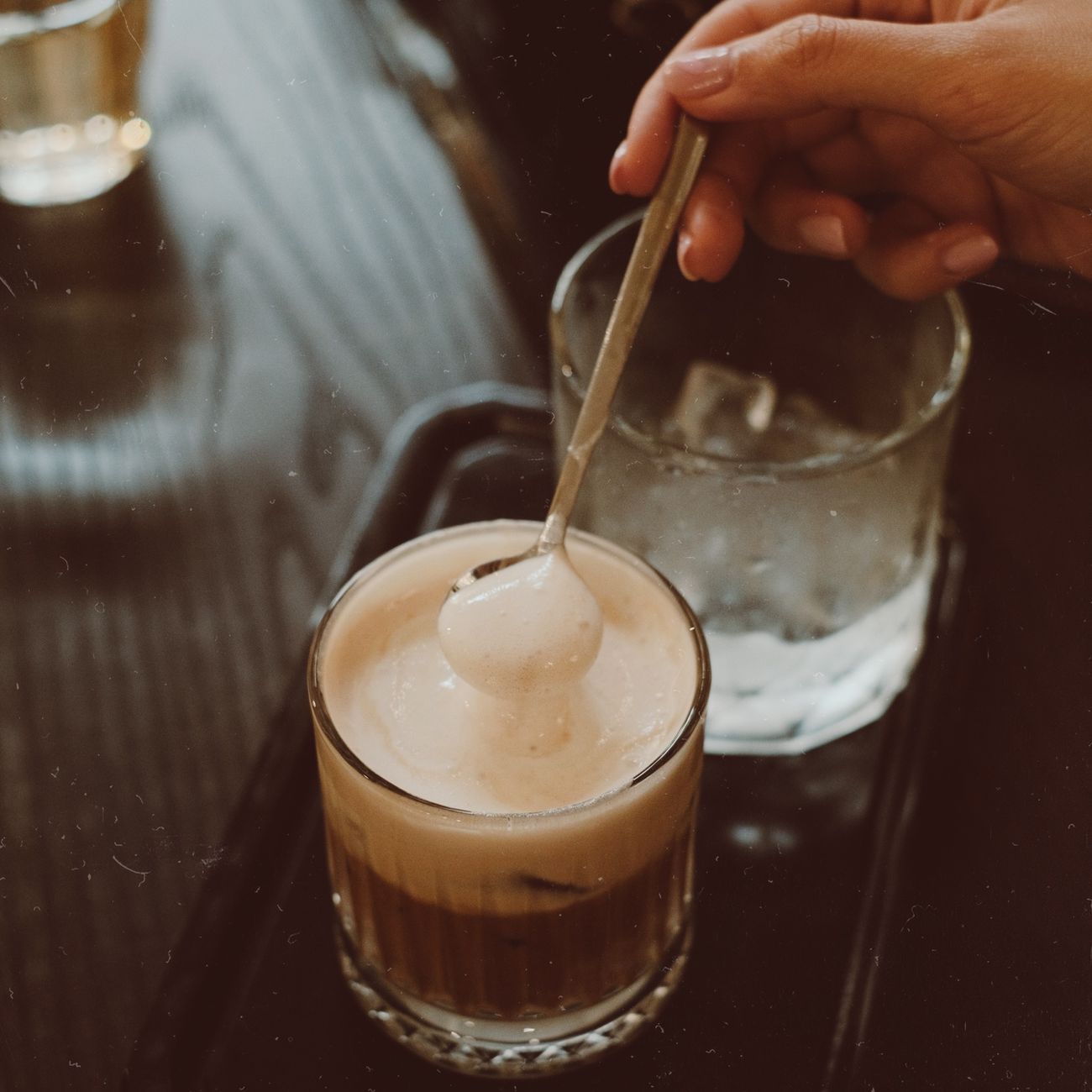 Craftsman's hands carefully shaping a slender bamboo tea scoop over gentle heat to create the traditional curved form.