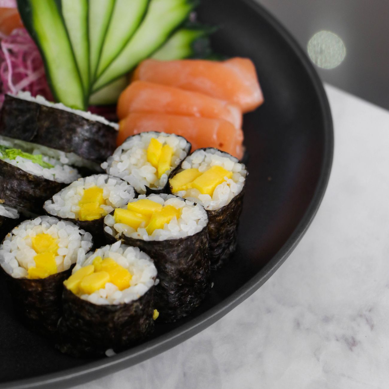 Fresh nigiri sushi arranged on hinoki cypress board showing tuna, sea bream, and kohada with wasabi in traditional Edomae style.
