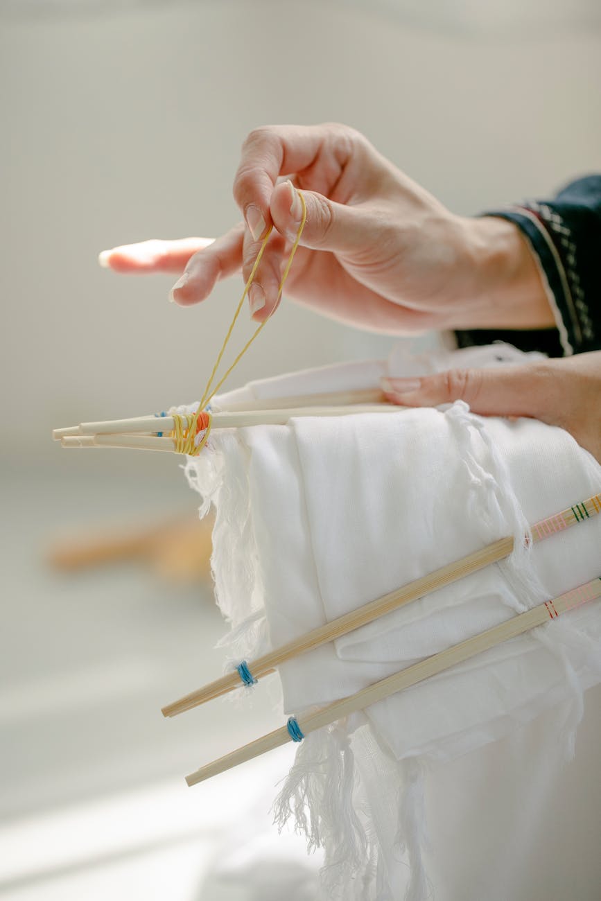 Traditional Japanese furoshiki cloth wrapping a gift box using diagonal fold technique with floral pattern fabric and knotted corners.