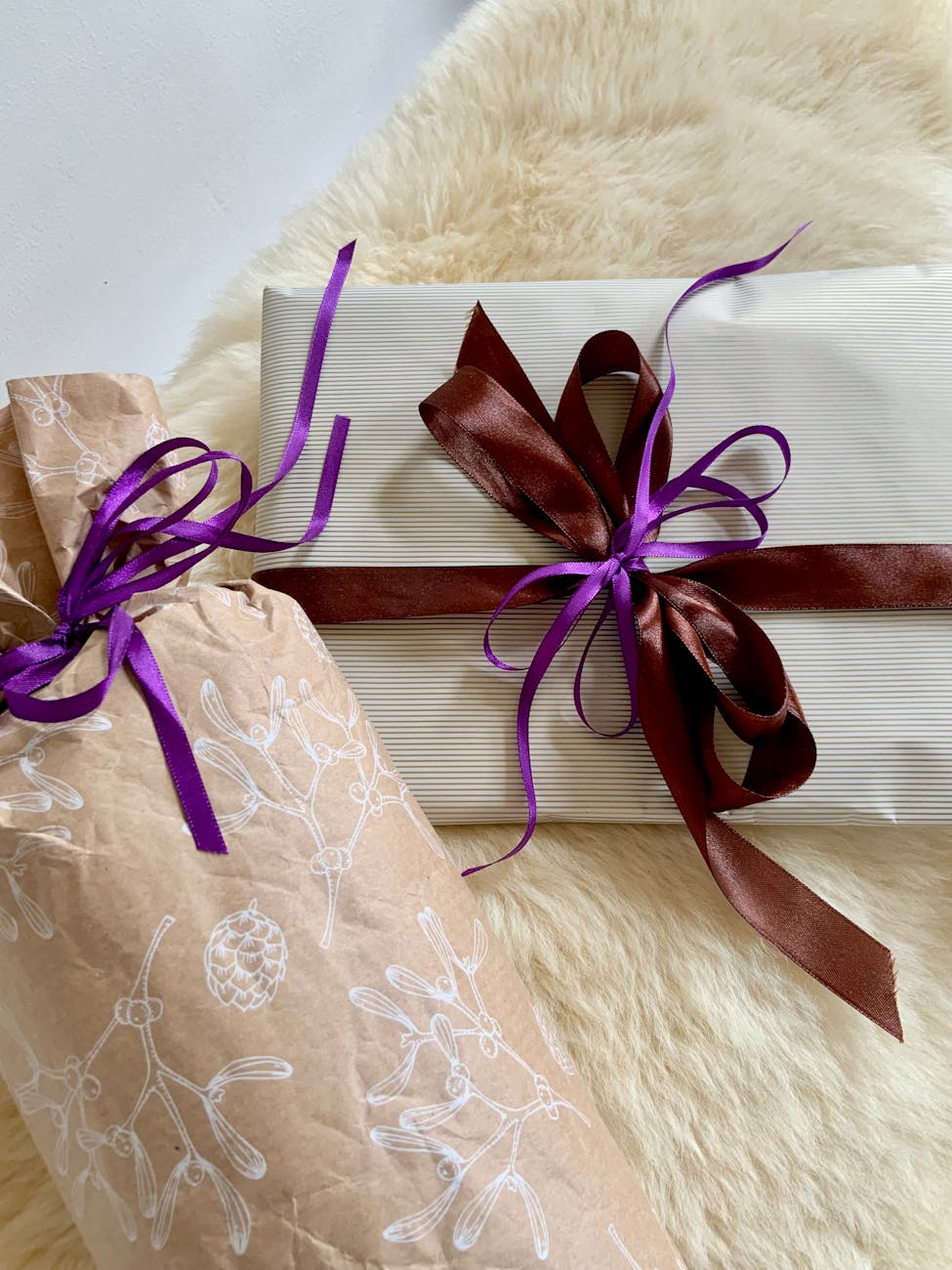 Wrapped gift boxes with traditional mizuhiki cord decorations arranged on a wooden table for Japanese seasonal gift-giving ceremony.