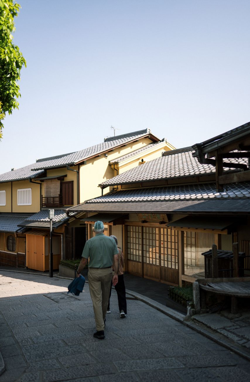 Traditional wooden tea house with sliding paper doors and tatami mat flooring in a serene Kyoto garden setting.
