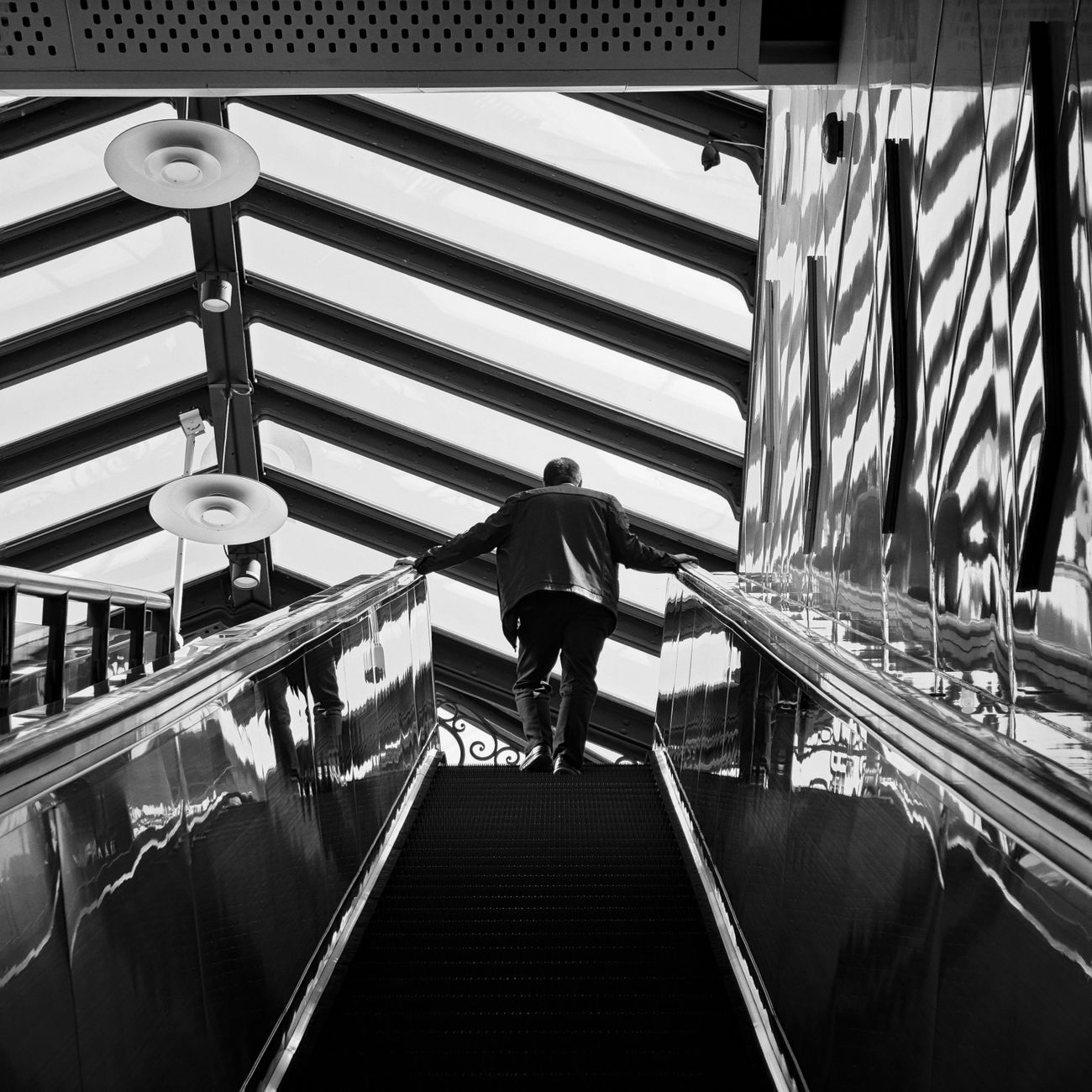 Commuters standing in a single-file line on the left side of a Tokyo metro station escalator during morning rush hour.