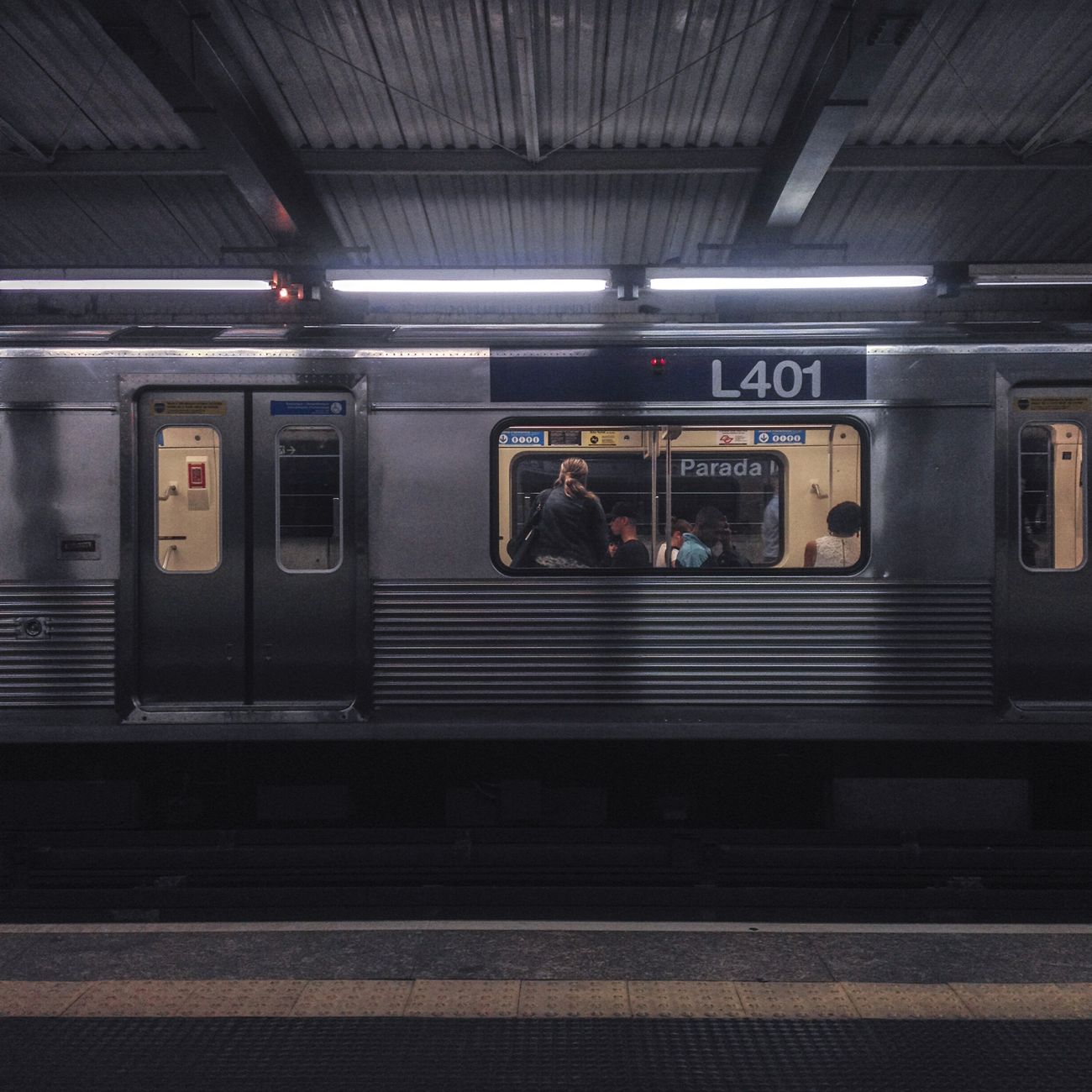 Commuters standing in orderly lines marked on a Tokyo train platform, waiting for the subway doors to align perfectly.