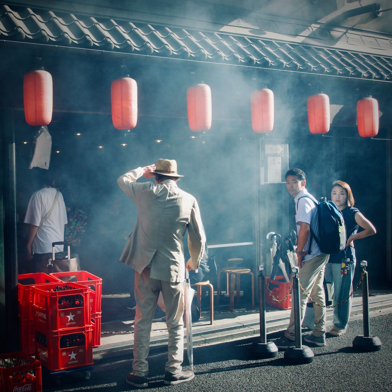 Two Japanese businesspeople bowing to each other at different angles on a city street in formal attire.