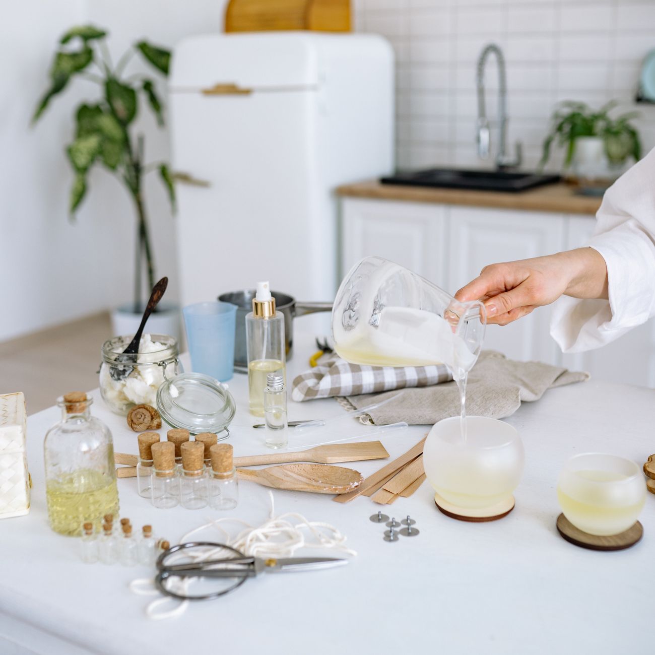 Person pouring clear tap water from a modern faucet into a transparent glass in a Japanese kitchen
