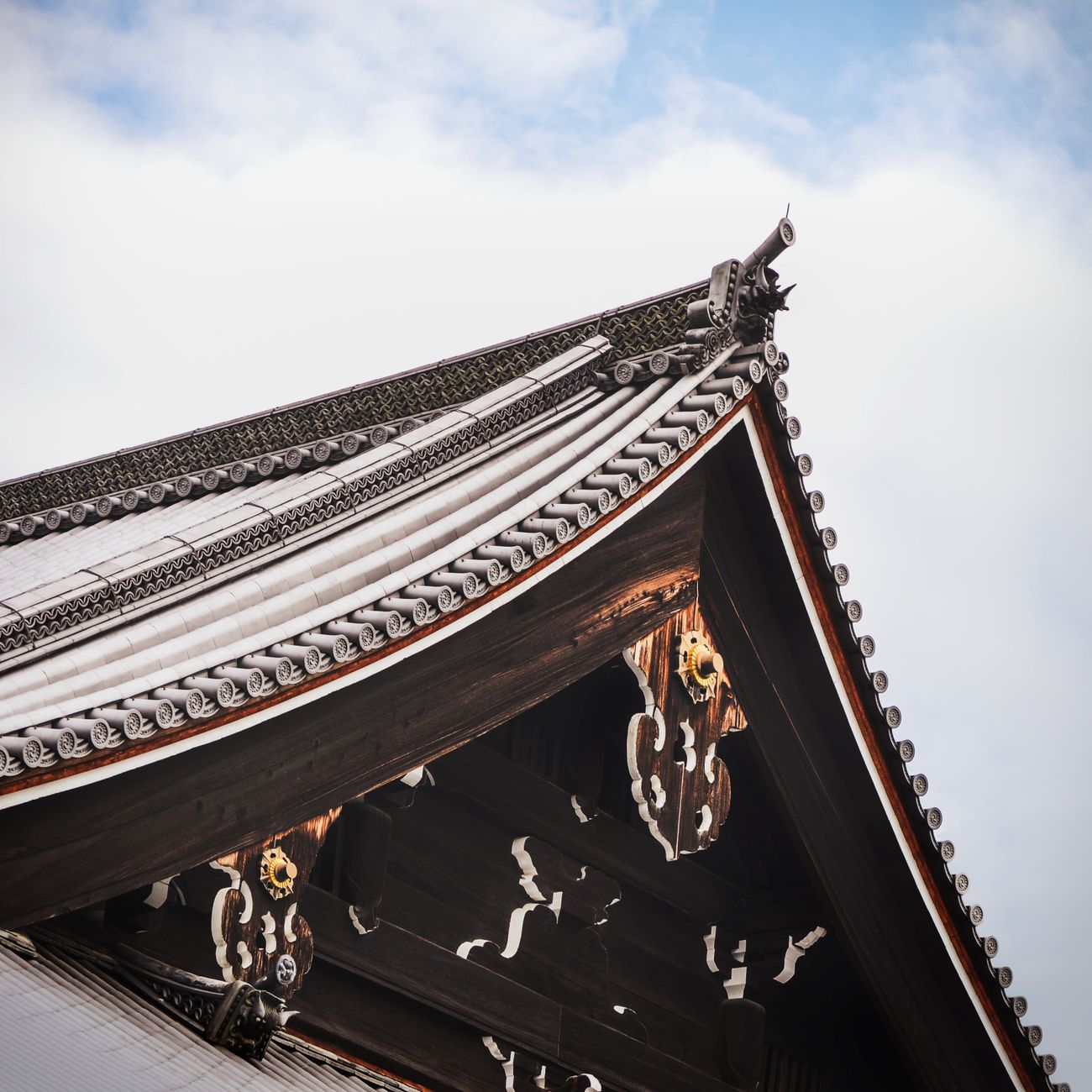 Traditional wooden machiya townhouses line a narrow stone-paved street in Kyoto's historic Higashiyama district at dusk.