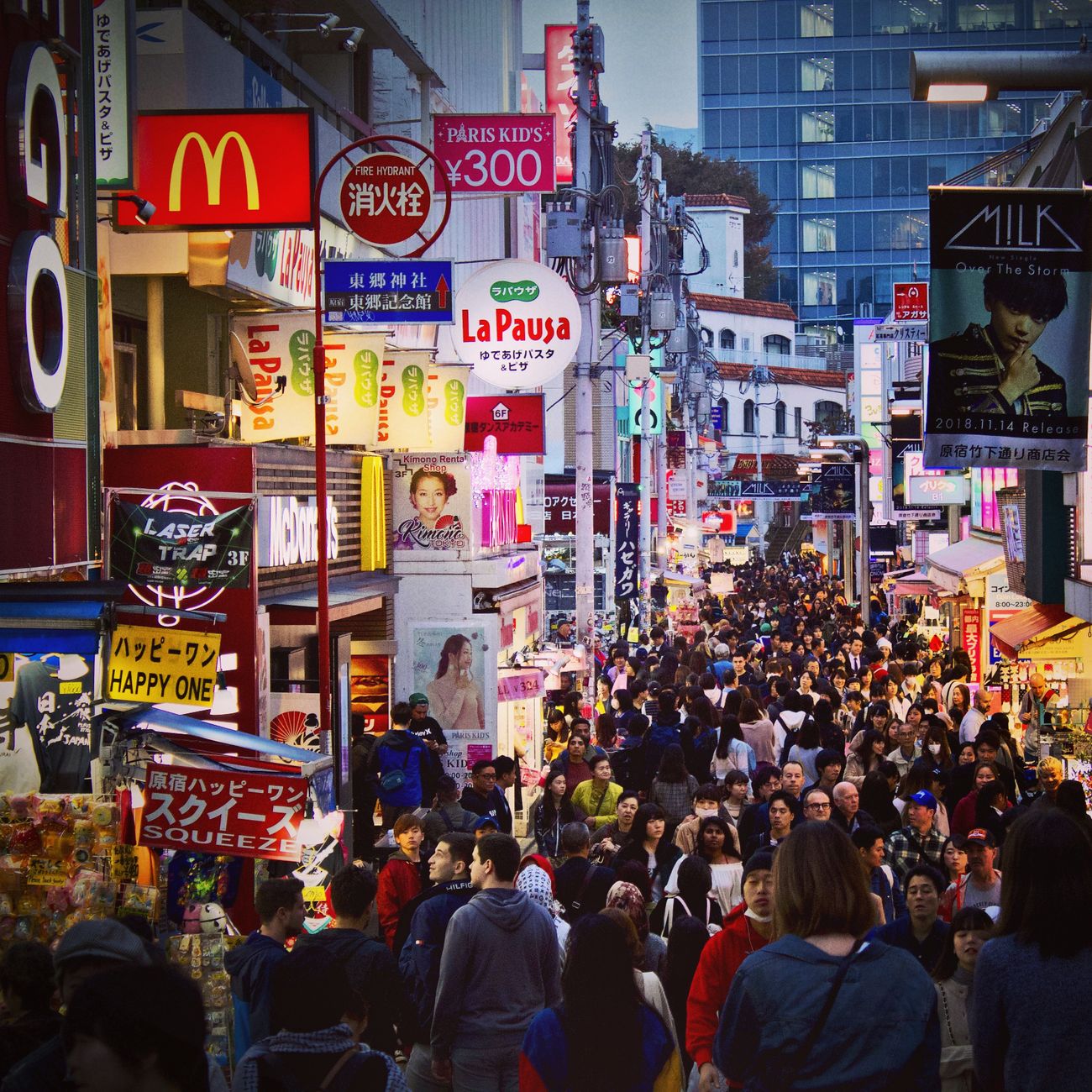 Pedestrians crossing the famous Shibuya intersection in Tokyo with orderly lanes and no collisions during rush hour.