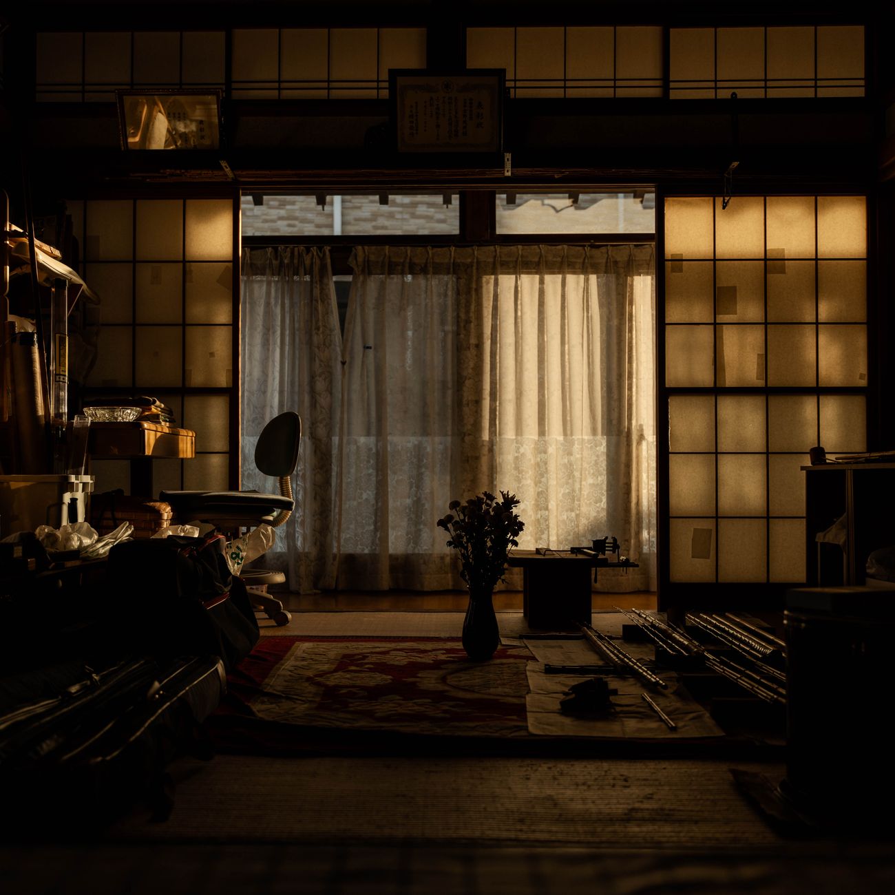 Family gathered around a low wooden kotatsu table covered with a thick quilted blanket in a traditional Japanese living room.