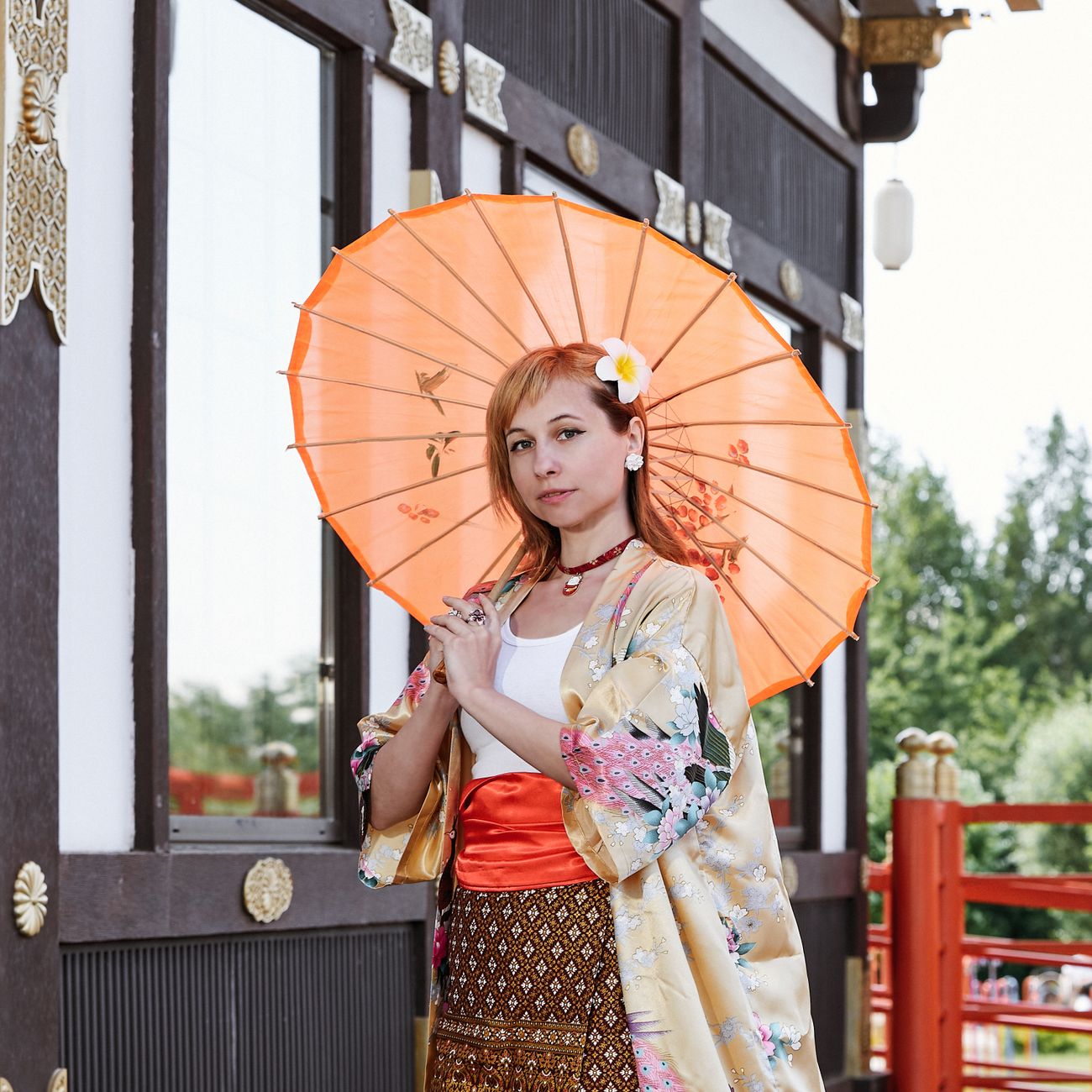 Young Japanese women wearing colorful patterned yukata with obi sashes walk together through a lantern-lit summer festival at dusk.