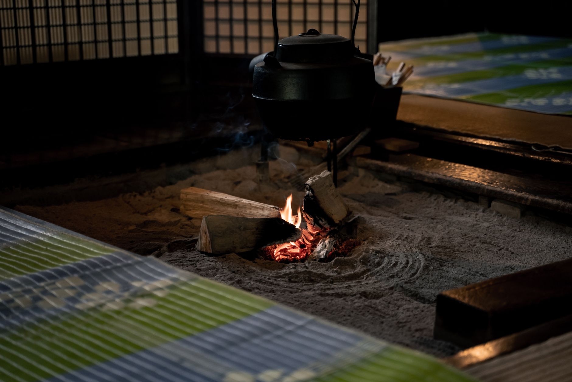 Traditional Japanese sento bathhouse interior showing wooden washing stations, tiled soaking pool, and Mount Fuji mural on the wall.