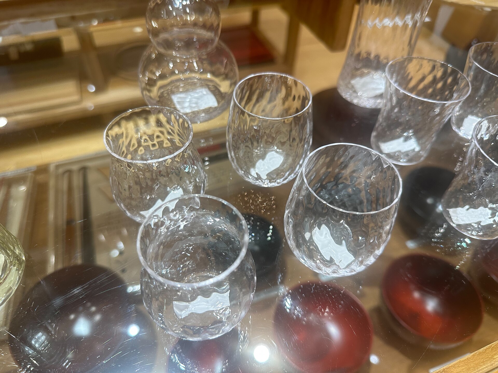 Traditional Edo Kiriko cut glass tumbler displaying intricate geometric star patterns carved into clear crystal against dark background.