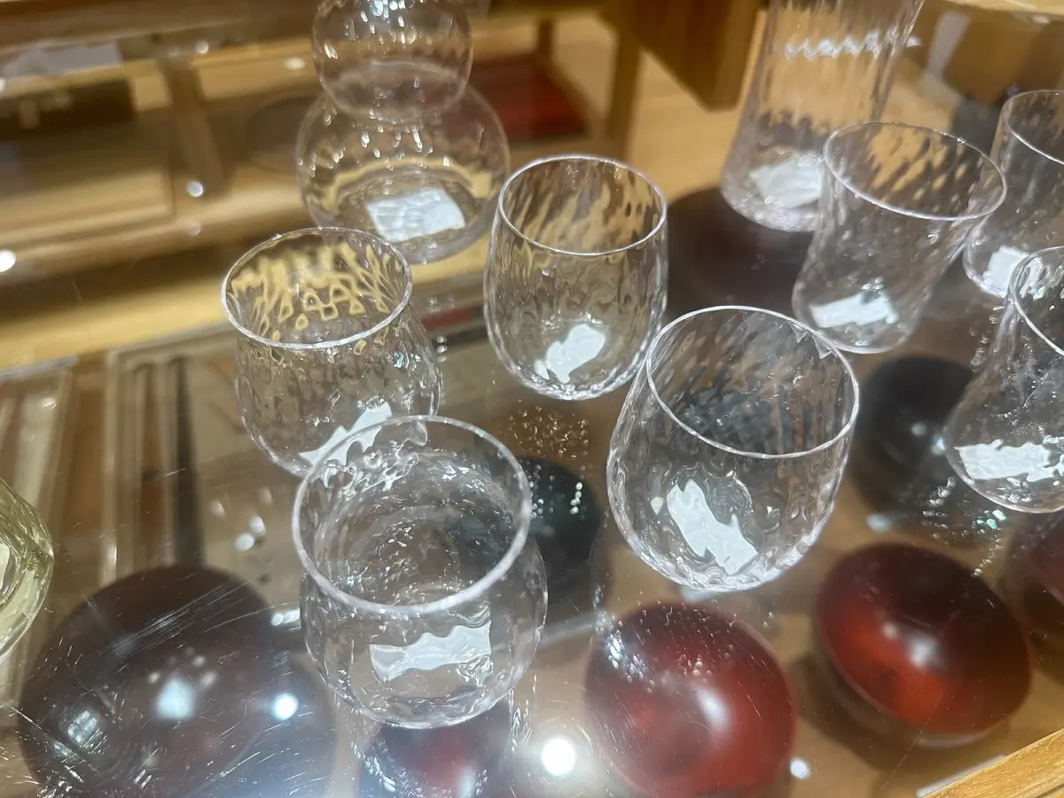 Traditional Edo Kiriko cut glass tumbler displaying intricate geometric star patterns carved into clear crystal against dark background.