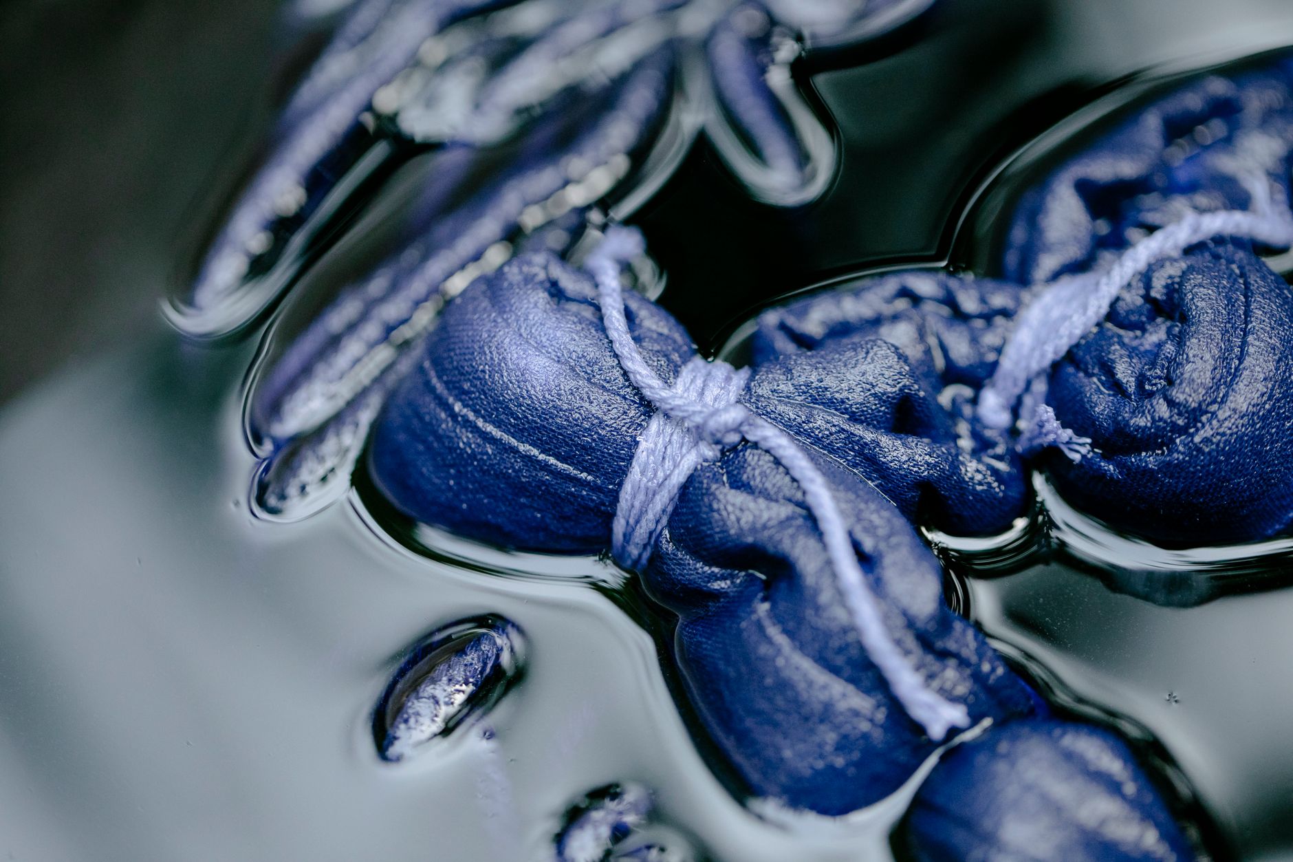 Indigo-dyed fabric hanging to dry in Tokushima, showing deep blue gradients from traditional awa ai fermentation dyeing.