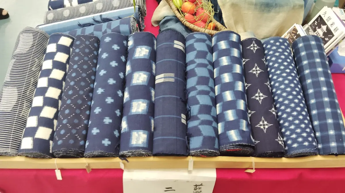 Traditional Japanese indigo kasuri fabric showing white geometric ikat patterns against deep blue cotton, displaying the distinctive Kurume weaving technique.