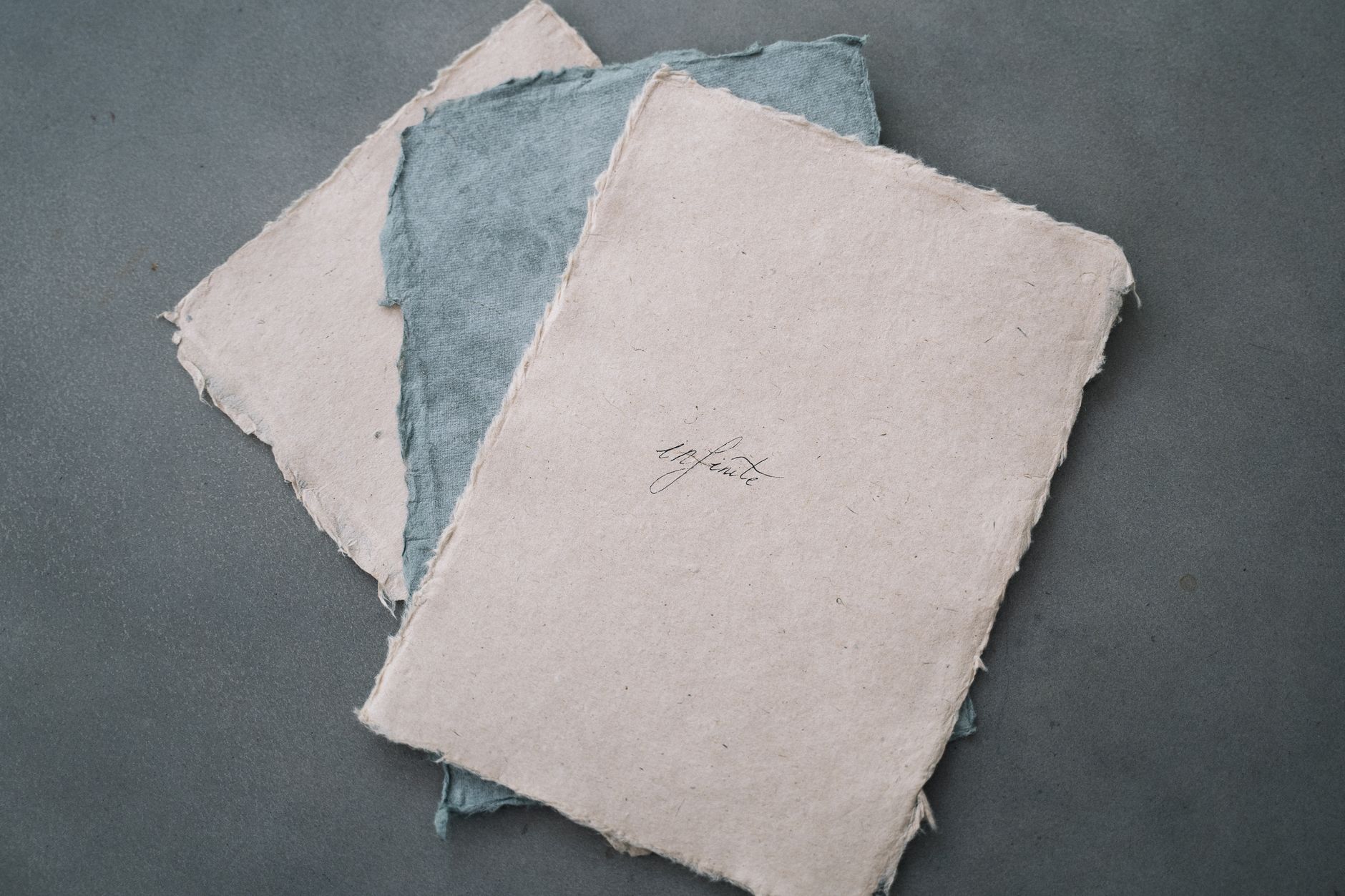 Artisan's hands carefully dipping a bamboo screen into pulp-filled water to form a translucent sheet of Tosa washi paper.