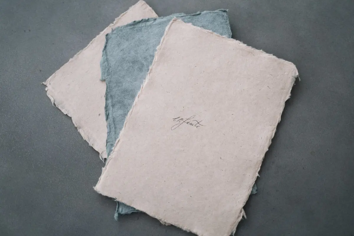 Artisan's hands carefully dipping a bamboo screen into pulp-filled water to form a translucent sheet of Tosa washi paper.