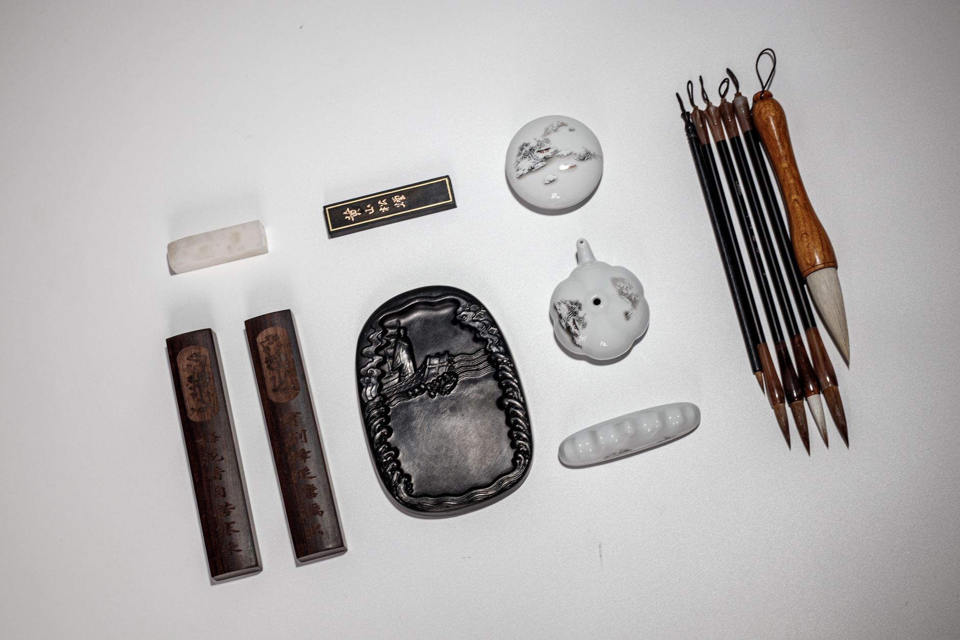 Artisan grinding pine soot with natural glue on a flat stone to create traditional Nara sumi ink sticks.