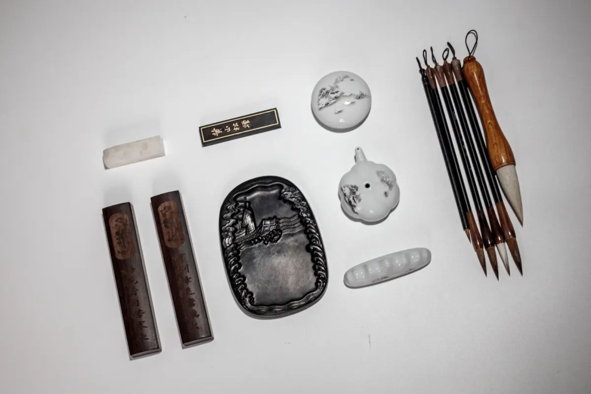 Artisan grinding pine soot with natural glue on a flat stone to create traditional Nara sumi ink sticks.