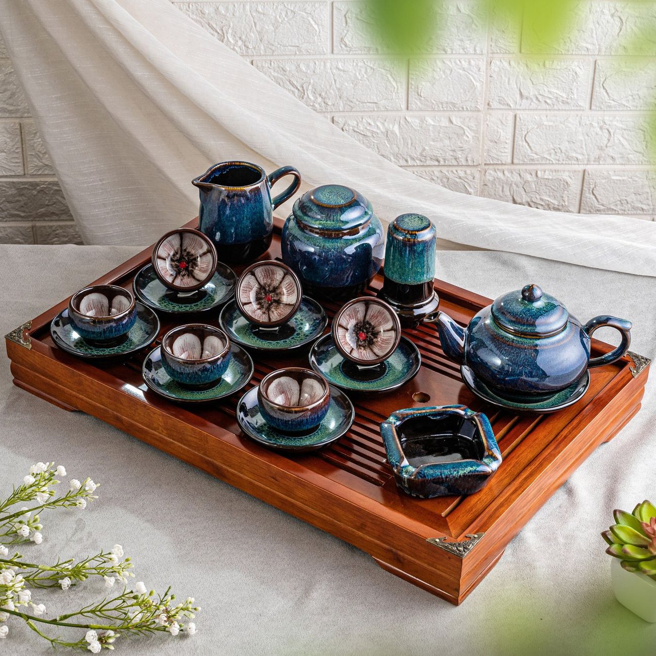 Stack of simple white Hasami ware plates and bowls arranged on a wooden table in a Japanese home kitchen.