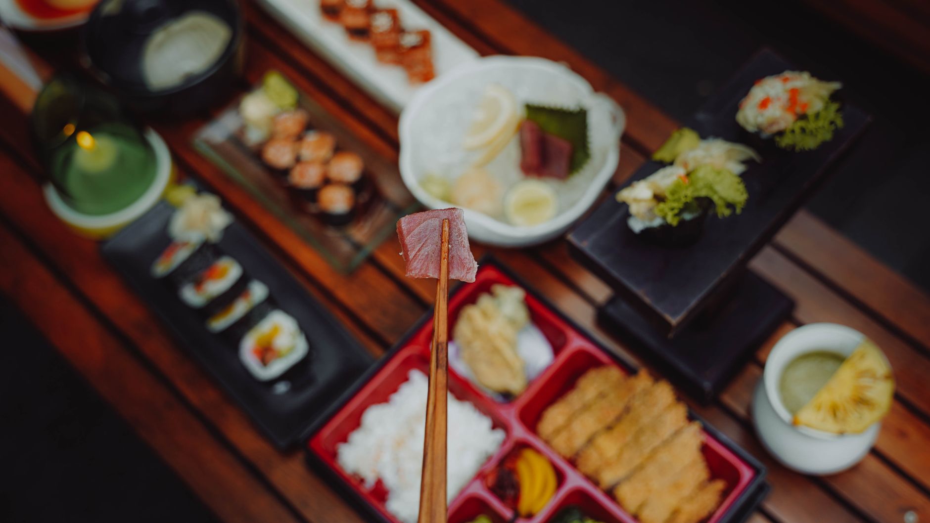 Traditional Japanese meal arrangement showing a bowl of miso soup, rice, grilled fish, pickled vegetables, and simmered vegetables on a wooden tray.