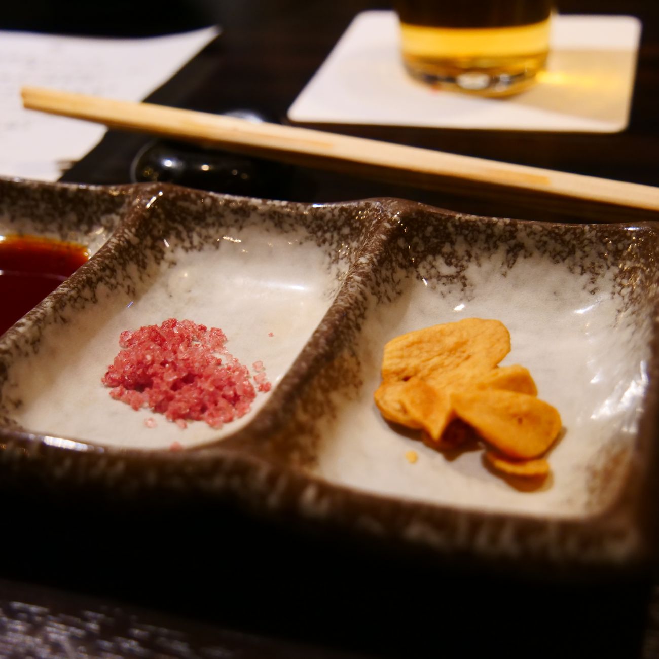 Traditional Japanese meal arrangement showing a bowl of miso soup, rice, grilled fish, pickled vegetables, and simmered vegetables on a wooden tray.