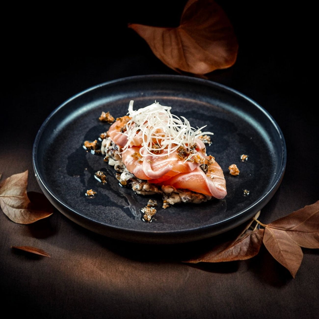 Spring kaiseki course featuring sakura-decorated ceramic plate with bamboo shoot, seasonal vegetables, and delicate pink cherry blossom garnish.