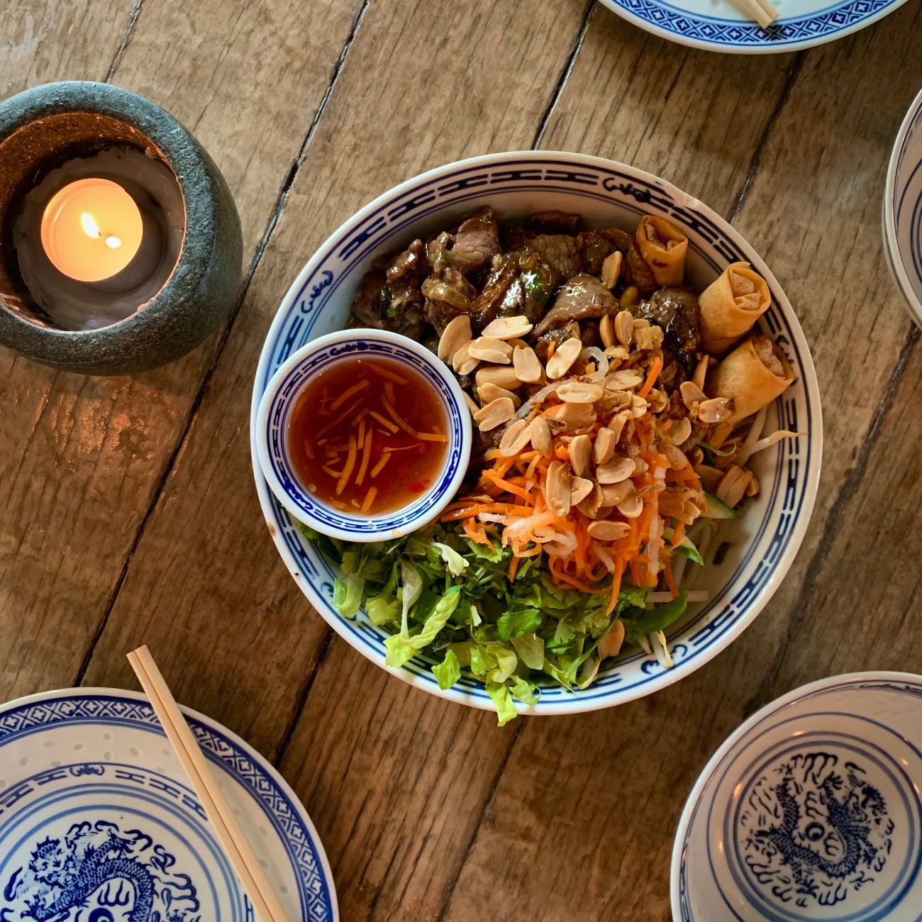 Traditional Japanese lacquer bowl and ceramic bowl side by side on wooden table displaying contrasting textures and finishes for soup service.