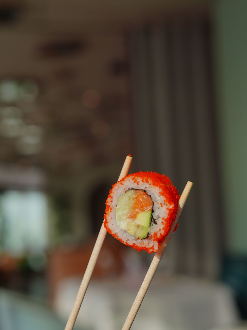 Artisan's hands applying fine gold powder to lacquered chopsticks using a delicate brush in traditional maki-e technique.